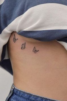 a woman's stomach with butterflies tattoo on her side, and the bottom part of her belly