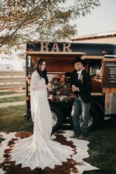 a man and woman standing in front of a food truck