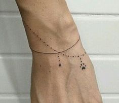 a woman's hand with a tiny black dot tattoo on the left side of her wrist