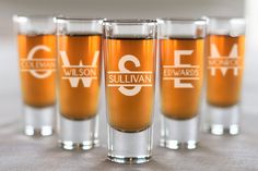 four shot glasses sitting on top of a table with the name sulllivan printed on them