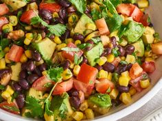 a white bowl filled with black beans, avocado and cilantro