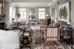 a living room filled with lots of furniture and flowers in vases on the table