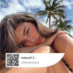 a woman laying on top of a beach next to palm trees