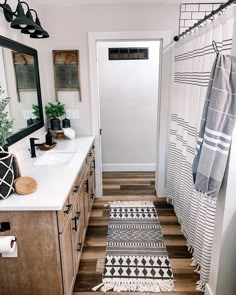 a bathroom with wooden floors, white walls and black accents on the shower curtain rod