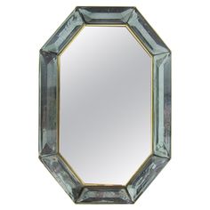 a mirror that is sitting on top of a white surface with an octagonal shape frame