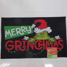 a christmas sign hanging from the side of a white wall with a grin face on it