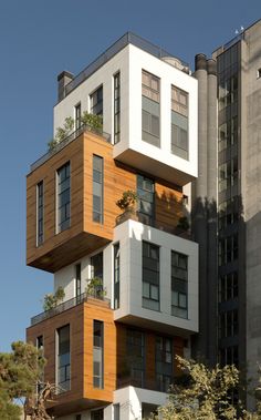 an apartment building with balconies and plants on top