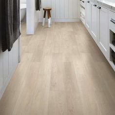 a kitchen with white cabinets and wood flooring on the walls is shown in this image