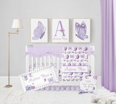 a baby's room with purple and white decor, crib bedding, and pictures