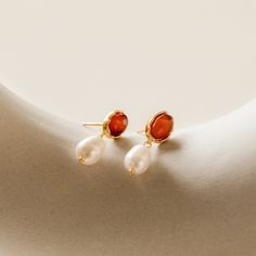 These beautiful earrings are made with Carnelian and Pearls, giving them a rich, earthy and feminine look. The Carnelian is a stone of purpose and passion, while the pearl represents purity of the heart. These eye-catching dangle earrings are sure to turn heads wherever you go. Material: High Quality Solid 925 Sterling Silver Finish: Sterling Silver ∙ 18K Gold Featuring ~10mm Carnelian Earrings with 9.5mm Fresh Water Pearl Dangling Charms Sold as a pair SKU: RR-ER307 Initial Tag Necklace, Pave Heart Necklace, Carnelian Earrings, New Gold Jewellery Designs, Heart Locket Necklace, Pearl Dangle Earrings, Initial Jewelry, Pearl Earrings Dangle, The Pearl