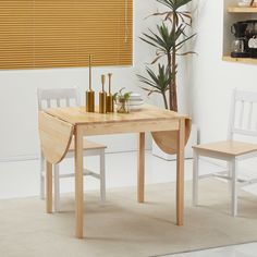 a wooden table and two white chairs in a room