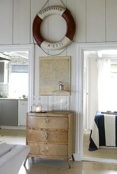 a living room filled with furniture and a life preserver hanging on the wall next to a bed