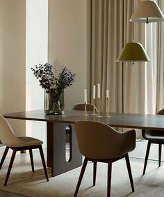 a dining table with two chairs and a vase filled with flowers