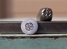 two metal knobs with four leaf clover on them