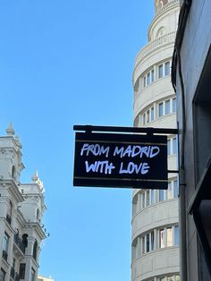 a sign hanging from the side of a building that says from madrid with love on it