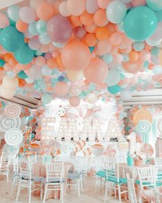 a room filled with lots of balloons and tables