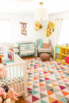 a baby's room with colorful rugs and furniture