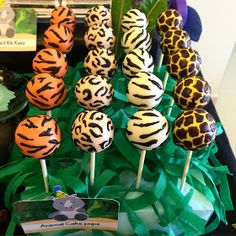 there are many zebra and giraffe cake pops on the table