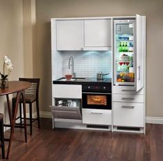 a kitchen with white cabinets and an open refrigerator