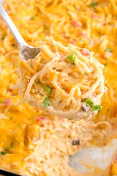 a spoon full of macaroni and cheese casserole being lifted from the casserole dish