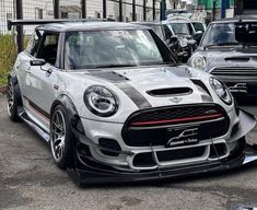 the front end of a white and black mini cooper