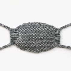 a gray knitted fish decoration on a white surface