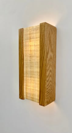 a wooden light fixture mounted to the side of a wall