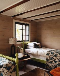 a bedroom with wood paneling and white bedding in an article about the great house