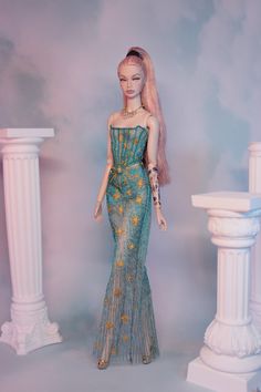 a barbie doll is standing in front of pillars and wearing a dress with flowers on it