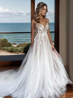 a woman standing in front of a window wearing a wedding dress with flowers on it