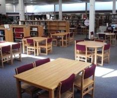 a library filled with lots of wooden tables and chairs