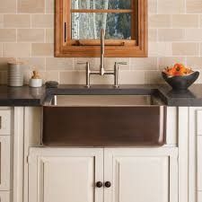 a kitchen sink sitting under a window next to a counter