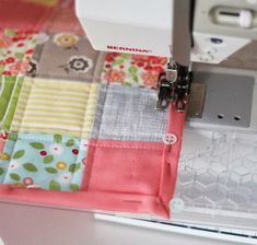 the sewing machine is on top of the patchwork material that has been sewn