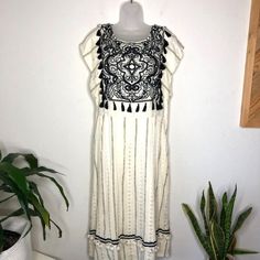 New Anthropologie X Maeve Anaya Ivory White Black Tassel Midi Dress. Size 12 But Tag Says 16. This Runs Very Small For A 16 And I Would Say It Is A 12, See Measurements Size: 12 Waist: 18" Bust: 20" Length: 47" Style Terms: Embroidered Boho Please See Photos For Measurements In Inches. We Are Happy To Answer Any Questions You May Have! Chic White Dresses With Tassels, Chic White Dress With Tassels, White Bohemian Dress With Tassel Ties, Elegant Beige Tassel Dresses, Beige Maxi Dress With Tassels, Chic White Tassel Dress, Chic White Maxi Dress With Fringe, Cotton V-neck Dress With Tassels, Anthropologie Dress