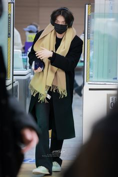 a woman wearing a face mask while walking through an airport