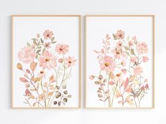 two pink flowers are on the wall next to each other, and one is framed in wood