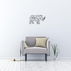 a white couch sitting on top of a wooden floor next to a potted plant