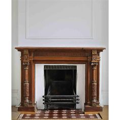 an antique fireplace with carved wood surrounds and a rug on the floor in front of it