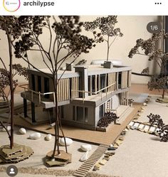 a model of a house with trees and rocks on the ground next to each other