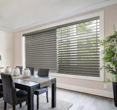 a dining room table and chairs with blinds in the window