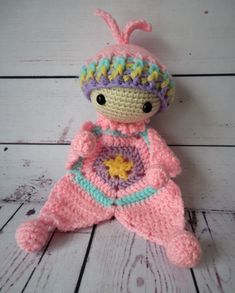 a crocheted doll is laying on the floor