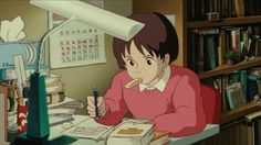 an anime character sitting at a desk writing