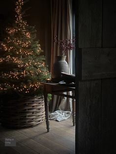 a small christmas tree is lit up by the light of a candle in a dark room