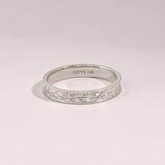 a white gold wedding band with engraved engraving on the side and an inscription that reads, lucky's six