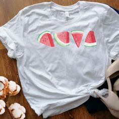 ** Cottage core watermelon tee - unisex ** Check sizing chart prior to ordering ** Visit our shoppe at:  ThePawPrintShoppe.etsycom This unisex t-shirt is a beautiful piece of clothing designed for those who love the refreshing and colorful look of watermelon slices. The shirt features a graphic design of watermelon slices that has been printed onto soft, high-quality cotton fabric. The cotton material used for this t-shirt is very soft to the touch, making it comfortable to wear for extended per Green Summer Shirt With Funny Print, Red Fruit Print Tops For Summer, Summer Green Tops With Funny Print, Cute Summer Shirt With Strawberry Print, Pink Fruit Print T-shirt For Summer, White Summer Shirt With Fruit Print, Summer White Shirt With Fruit Print, White Fruit Print Shirt For Summer, Cotton Vacation Tops With Fruit Print