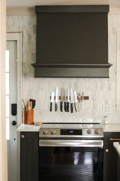 a stove top oven sitting inside of a kitchen next to a wall mounted range hood