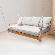 a wooden swing bed with white pillows on it