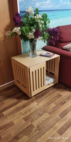 a living room with a couch, coffee table and flowers on the end table in front of it