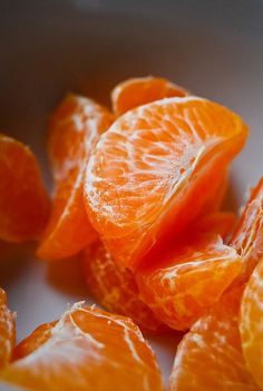 peeled oranges sitting on top of a white plate