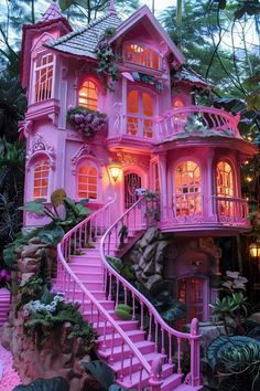 a pink doll house is lit up in the evening with windows and balconies